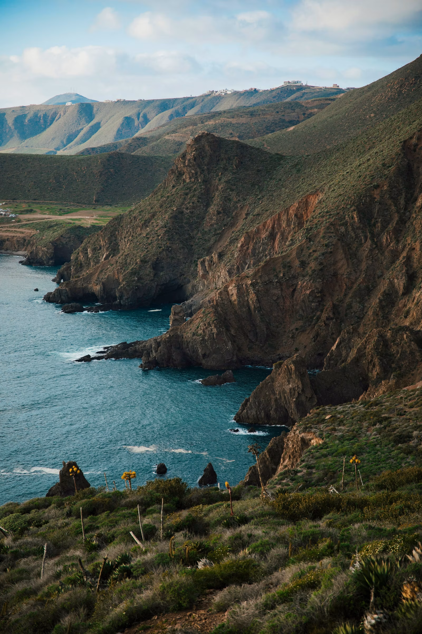 Rocky Baja California coastal landscape meeting calm water, warm light, Mexico